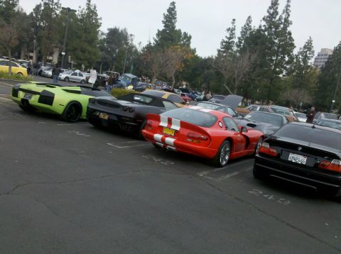 2004 Ford Crown Victoria - A collection of high-performance vehicles are parked in a lot, with a red Dodge Viper prominently displayed.