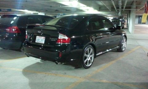 2008 Subaru Legacy - A black Subaru Legacy sedan is parked in a garage next to another vehicle.