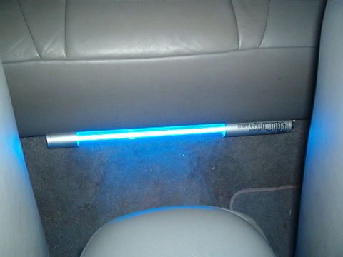 1998 Ford Taurus - A blue LED light strip is installed under the rear seat of a car, illuminating the floor.