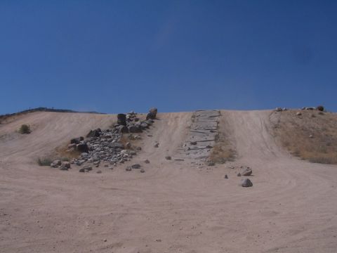 1990 Ford Bronco - A dirt hill with concrete steps and rocks is visible under a clear blue sky.