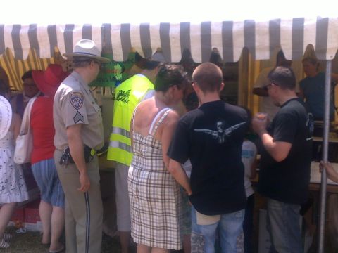 1991 Ford LTD Crown Victoria - A group of people are seen at an outdoor event, with a law enforcement officer standing among them.