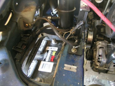 1995 Ford Probe - Close-up view of an engine bay, focusing on the battery and alternator components.