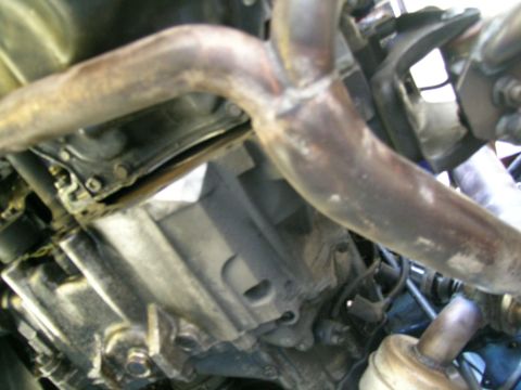 1995 Ford Probe - Close-up of a vehicle's undercarriage, focusing on the exhaust system and engine components.