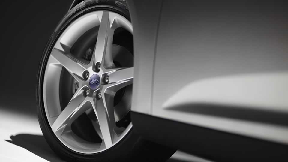 Close-up of a silver 5-spoke wheel with a blue Ford logo center cap