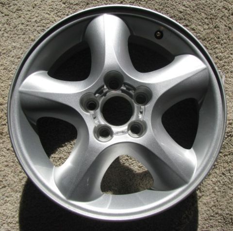 1993 Ford Taurus - A single silver car wheel is shown against a carpeted background.