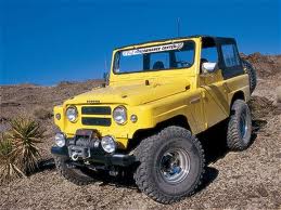 1991 Ford Bronco - This yellow off-road SUV is equipped with a winch and aftermarket wheels, suggesting it is built for terrain.