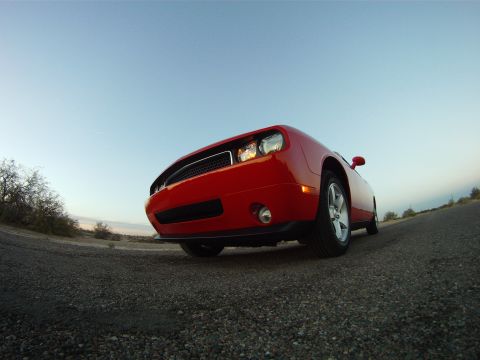 2010 Dodge Challenger - A red Dodge Challenger is parked on a gravel road with a clear blue sky overhead.