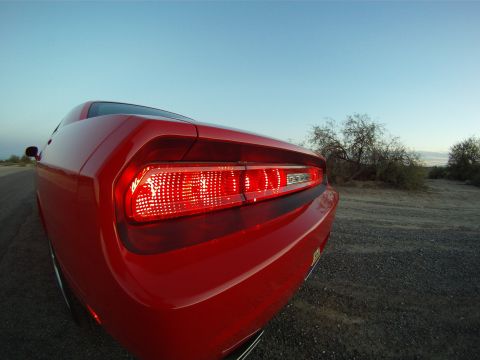 2010 Dodge Challenger - Rear view of a red Dodge Challenger parked on a gravel road with desert scrub in the background.
