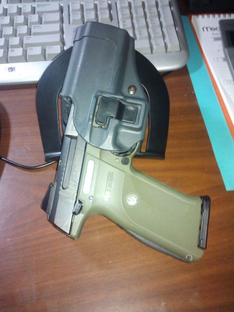 1989 Ford Bronco - A handgun rests in its holster on a desk next to a computer keyboard.
