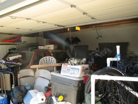 1986 Ford Bronco - A cluttered garage scene with various items including car parts and furniture.