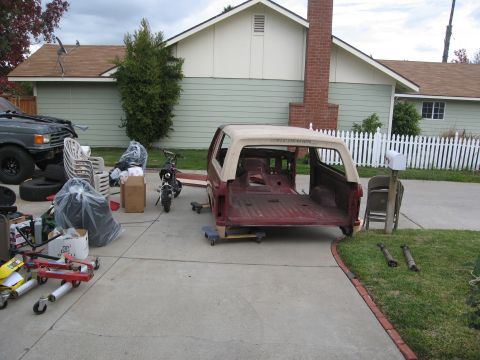 1986 Ford Bronco - The body of a Ford Bronco is staged in a driveway, awaiting restoration or parts.