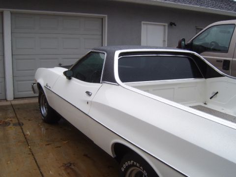 1973 Ford Ranchero - White 1973 Ford Ranchero with a black vinyl top parked in front of a garage.