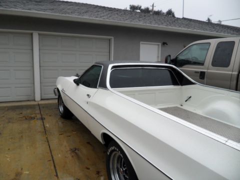 1973 Ford Ranchero - A white 1972 Ford Ranchero is parked next to a silver pickup truck in front of a residential garage.