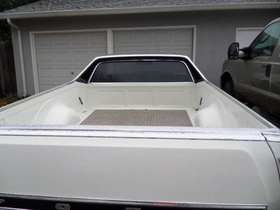 1973 Ford Ranchero pickup bed, white exterior, with a second vehicle visible to the right