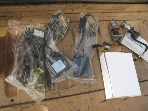 1986 Ford Bronco - HID conversion kit parts, including ballasts, wiring, and bulbs, are visible in plastic packaging and loose.