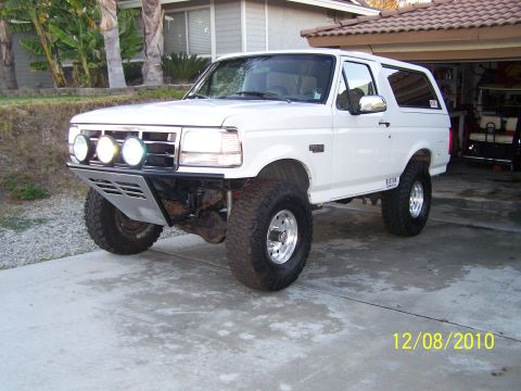 1995 Ford Bronco - White 1995 Ford Bronco parked in a driveway with a custom front bumper and off-road tires.