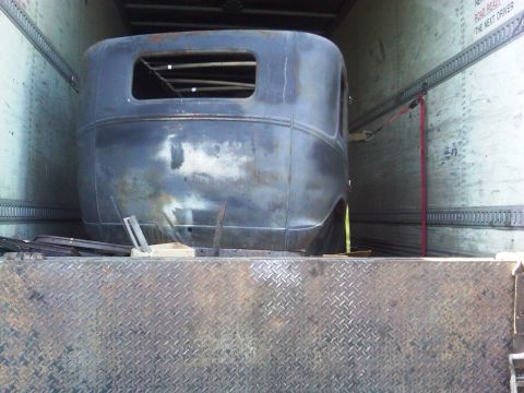 1986 Ford Bronco - The rear body of a 1931 Ford Model A Fordor is secured inside a trailer.