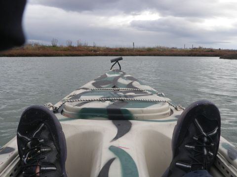 1991 Ford Bronco - View from inside a camouflage kayak on the water under a cloudy sky.