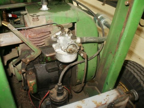 1966 Ford Bronco - Close-up view of a green engine with its carburetor and associated components.