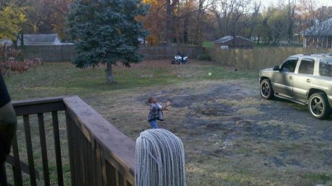 2007 Yamaha Raptor 700 - An ATV is parked in a grassy backyard with a child and an SUV nearby.