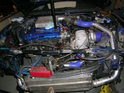 1995 Ford Probe - Custom turbo setup installed in a vehicle's engine bay, an intercooler and blue piping.