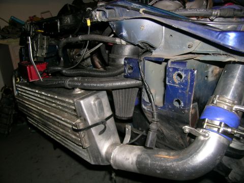 1995 Ford Probe - Close-up view of custom intercooler and intake plumbing in a vehicle's engine bay.