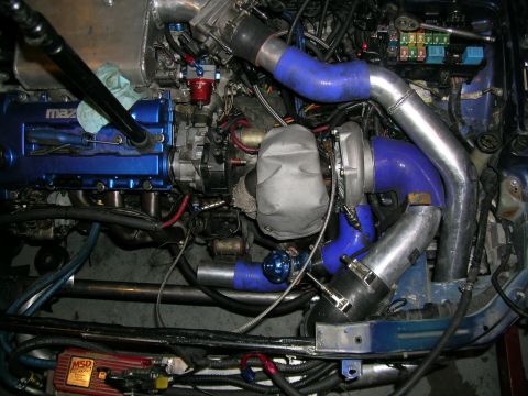 1995 Ford Probe - Custom engine bay modifications with a prominent turbocharger and blue silicone piping are visible.
