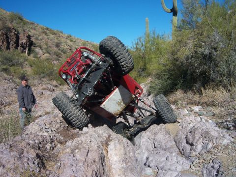 Suzuki Samurai - An off-road buggy has tipped onto its side while navigating a rocky desert trail.