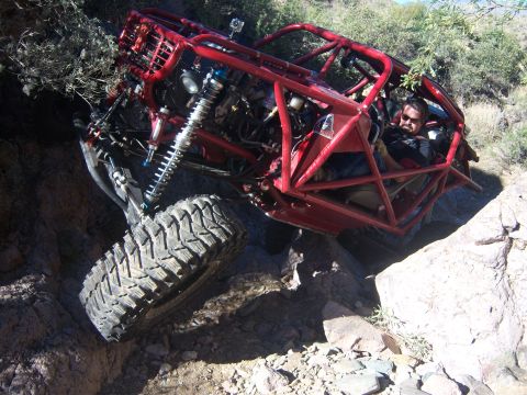 Suzuki Samurai - A driver maneuvers a custom-built off-road buggy through a challenging rocky terrain.