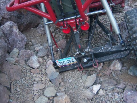 Suzuki Samurai - Close-up of an off-road vehicle's rear suspension system on rocky terrain.