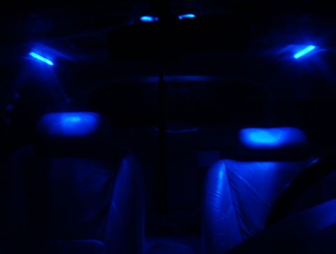 1998 Ford Taurus - The interior of a vehicle is illuminated with blue ambient lighting, highlighting the seats and overhead lights.