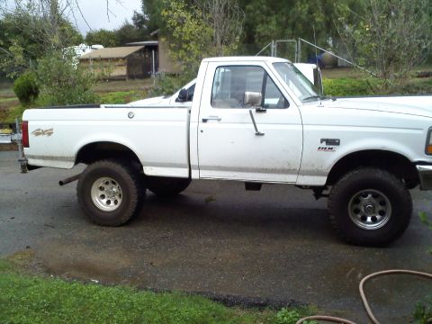 1995 Ford F-150 - Side view of a white 1995 Ford F-150 pickup truck parked outdoors.