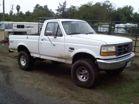 1995 Ford F-150 - This 1995 Ford F-150 pickup truck is shown from the front three-quarter view on a dirt road.