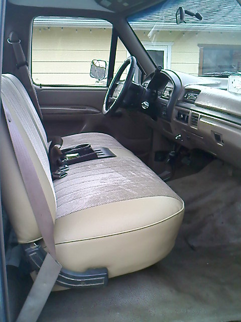 1995 Ford F-150 - The interior of a 1995 Ford F-150 shows a tan bench seat and dashboard.