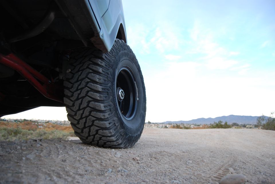 Off-road tire and red suspension components on a dirt surface