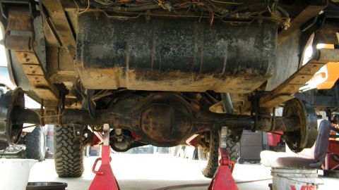 1982 Ford Bronco - The rear axle, leaf springs, and fuel tank of a 1978 Ford Bronco are visible from underneath.