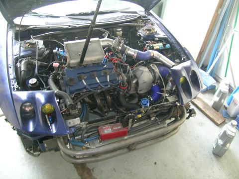 1995 Ford Probe - The engine bay of a car is shown with extensive modifications, including a turbocharger and intercooler system.