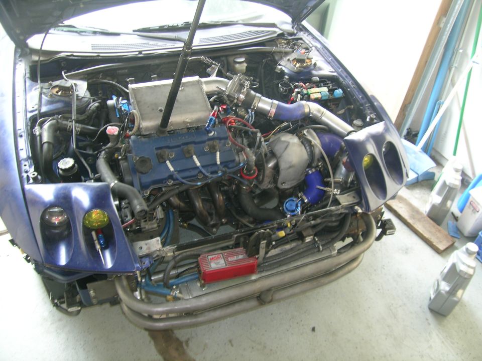 car engine bay with turbocharger, intercooler, and custom piping