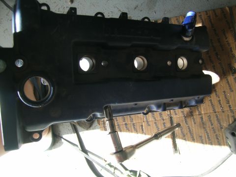 1995 Ford Probe - A black engine valve cover is shown with tools on a surface covered in shipping labels.