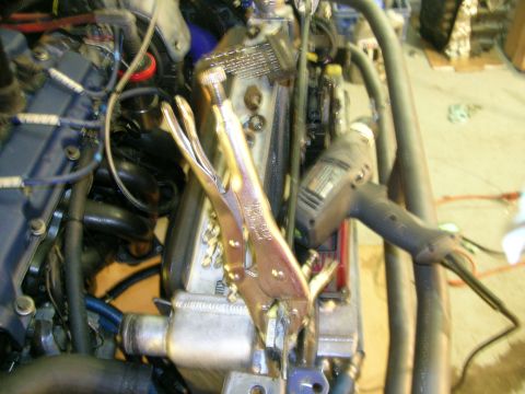 1995 Ford Probe - Close-up view of an engine bay with tools, including vice grips and a drill, attached to components.