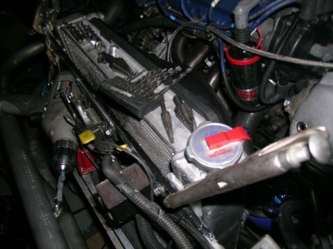 1995 Ford Probe - Close-up view of an engine bay, showing various components and tools, including a drill and radiator cap.
