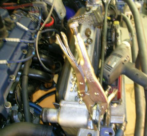 1995 Ford Probe - Close-up view of an engine bay with tools, including vice grips and a drill, obscuring some components.