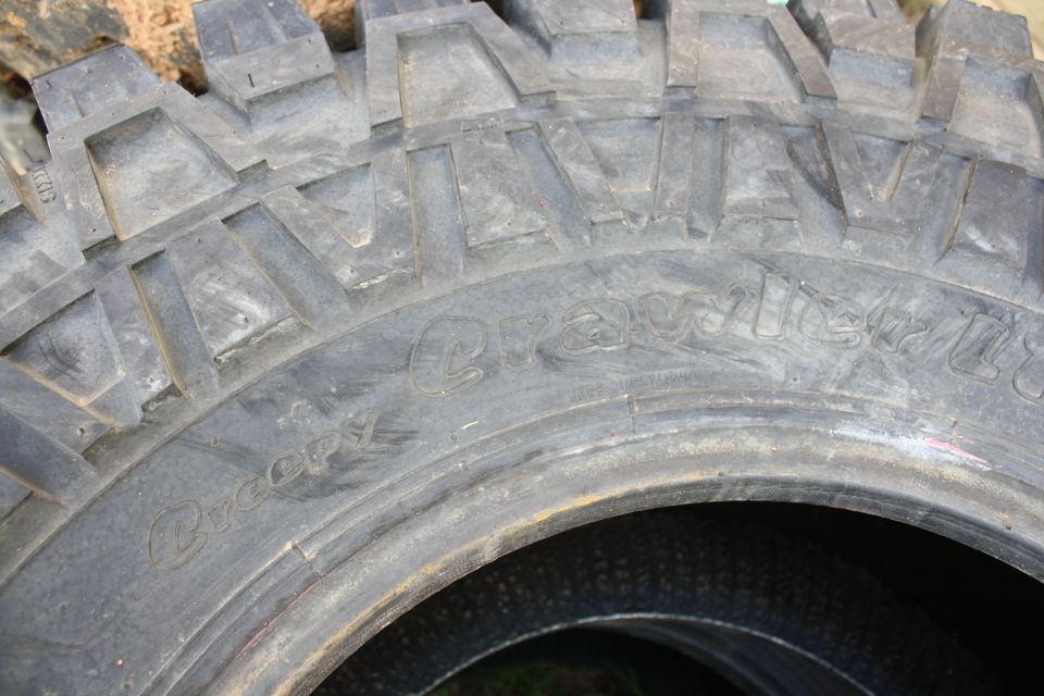 Tire with aggressive tread pattern, showing "Creepy" and "Crawlers" text molded into the sidewall