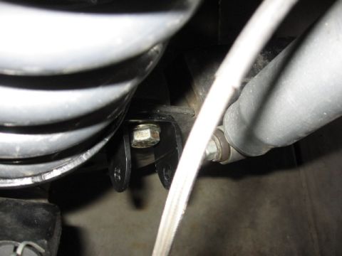 1995 Ford Bronco - Close-up view of dual front shock mounts, showing a bolt securing the bracket to the vehicle frame.