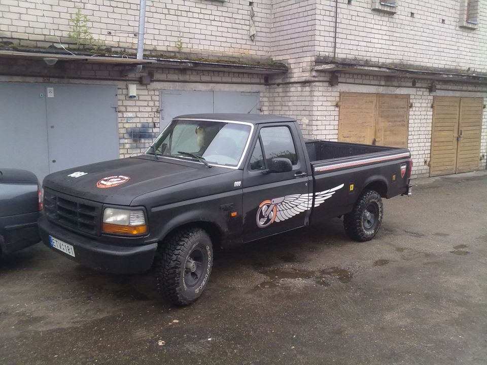 1995 Ford E150 pickup truck, black with winged decals on the side and hood