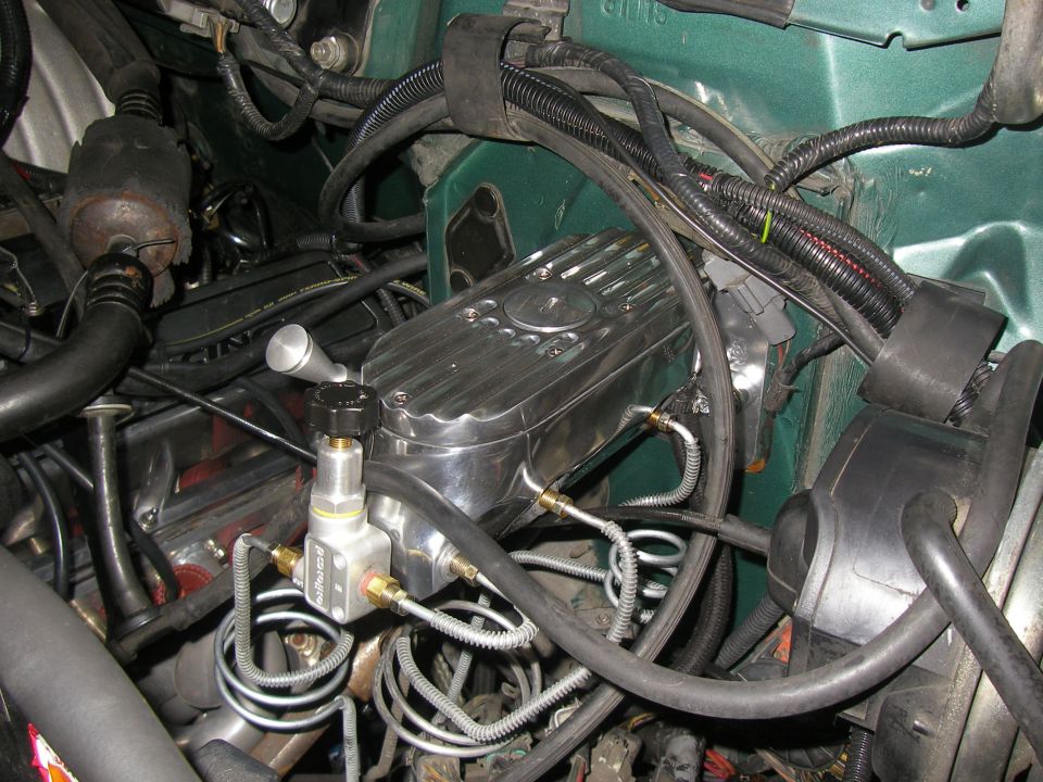 Engine bay with chrome finned valve cover, brake proportioning block and wiring
