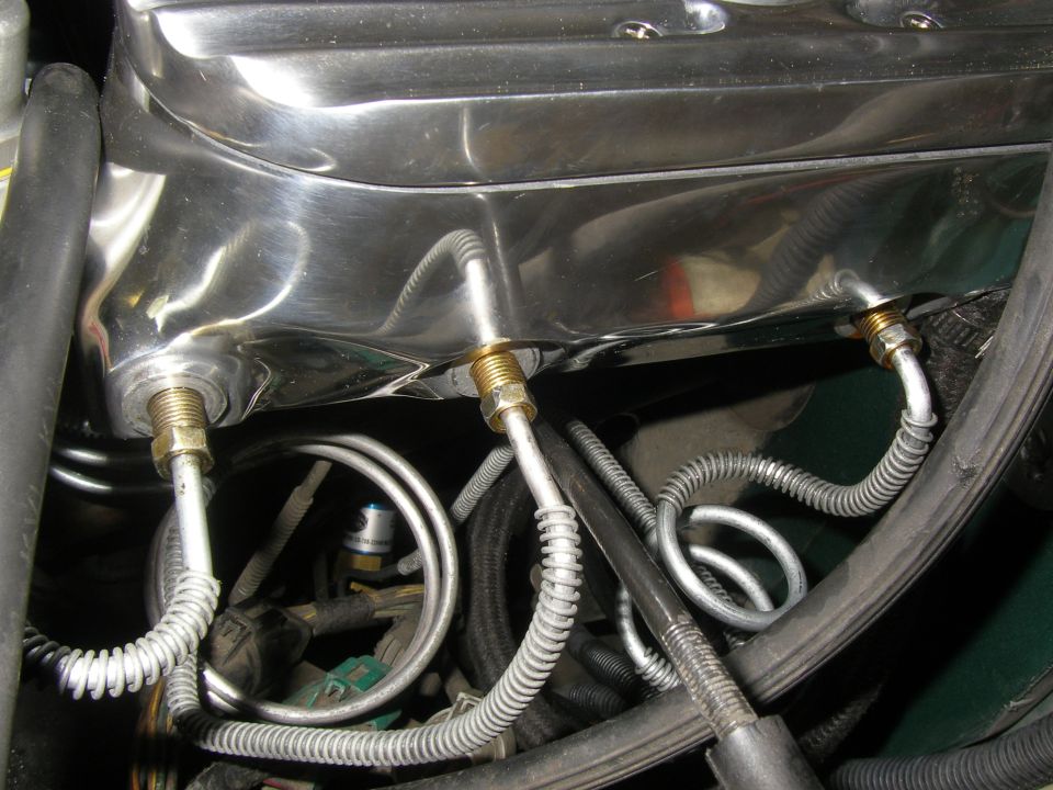 Chrome engine valve cover with metal brake lines attached