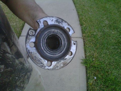 1995 Ford Bronco - A person holds a worn wheel hub assembly, likely removed from a vehicle for repair or replacement.