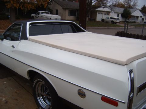 1973 Ford Ranchero - A white coupe utility is parked in a residential driveway, showing its side profile and bed cover.