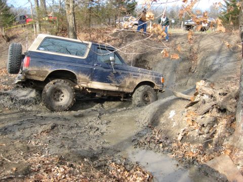 2005 Jeep Wrangler - This Ford Bronco navigates a challenging muddy obstacle during an off-road event.